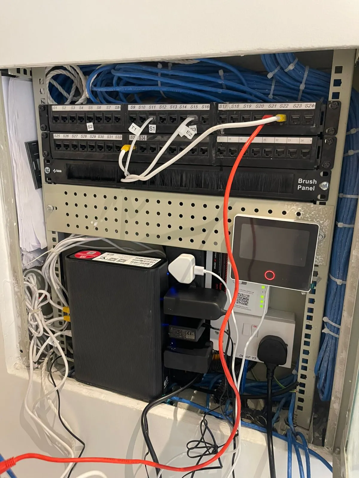 Cat6 patch panel with labeled ports and blue structured cabling